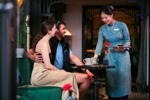 河内Hanoi Center Silk Classic Hotel & Travel的坐在桌子上的女人,男人和女人