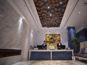 上海Shanghai Jinchen Hotel的坐在酒店大堂桌子上的两个人