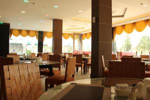 SengkuangThe Golden Bay Hotel Batam的用餐室设有桌椅和窗户。