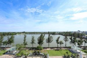 Bạc LiêuNew Palace Bac Lieu Hotel的棕榈树的一大片水景