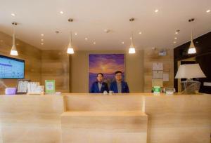 拉萨Lavande Hotels Potala Palace Najin Road的两个男人站在大厅的柜台后面