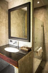 拉差汶里Phingphayla Photharam的一间带水槽、镜子和淋浴的浴室