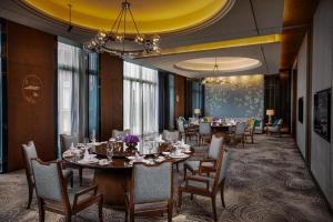 花都Guangzhou Rongchuang Jingshan Hotel的一间带桌椅的用餐室和黄色天花板