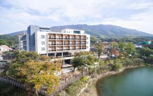 抱川市hotel gallery的水体旁的山丘上的建筑物