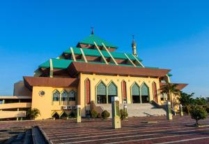 秾莎OYO 90024 Botania Homestay & Cafe的一座有绿色屋顶和建筑的清真寺