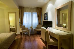 塞萨洛尼基戴维酒店的酒店客房设有书桌和卧室。