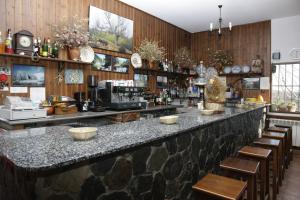 Arroyo de las FraguasHostal Restaurante Alto Rey的餐厅内拥有木墙的酒吧