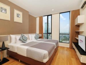 曼谷Mövenpick Residences Ekkamai Bangkok的一间卧室设有一张大床和大窗户