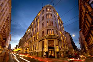 维也纳Flemings Selection Hotel Wien-City的夜幕降临的城市街道上一座高楼