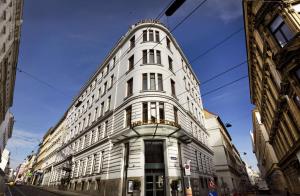 维也纳Flemings Selection Hotel Wien-City的一条城市街道上高大的白色建筑