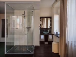 慕尼黑Flemings Hotel München-City的一间带玻璃淋浴间和水槽的浴室