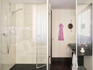 慕尼黑Flemings Hotel München-City的带淋浴的浴室和玻璃门
