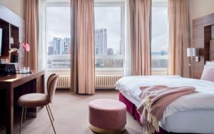 美因河畔法兰克福Flemings Selection Hotel Frankfurt-City的一间卧室配有一张床、一张书桌和一个窗户。