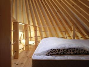 ZabierzówGlamping Pogorzany - Jurty的木天花板的客房内的一张床位