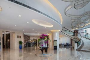 深圳Grand Soluxe Zhongyou Hotel Shenzhen的大厅,在大楼里设有楼梯和鲜花