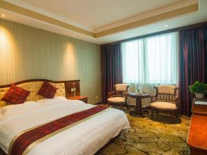 舟山GreenTree Alliance Zhejiang Zhoushan Putuoshan Zhujiajian Scenic Spot Hotel的酒店客房带一张床、一张桌子和椅子