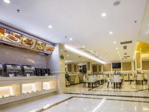 贵阳Vienna Hotel Guiyang Jiaxiulou Jichang Road的餐厅内带桌椅的用餐室