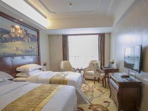 贵阳Vienna Hotel Guiyang Jiaxiulou Jichang Road的酒店客房设有两张床和一台平面电视。