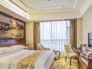 贵阳Vienna Hotel Guiyang Jiaxiulou Jichang Road的一间卧室配有一张大床、一张书桌和一个窗户。