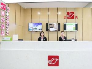 太原Shell Taiyuan South Station Shanxi University Hotel的两个女人坐在商店的柜台上