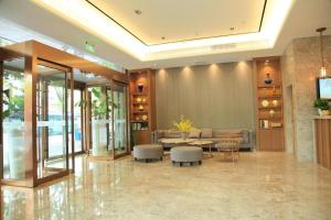 上海Home Inn Plus Shanghai Middle Ring Jinshajiang Road Fengzhuang Metro Station的大楼的大堂,配有桌椅