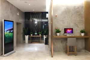 上海Home Inn Plus Shanghai Middle Ring Jinshajiang Road Fengzhuang Metro Station的大堂设有一张桌子和一台电脑