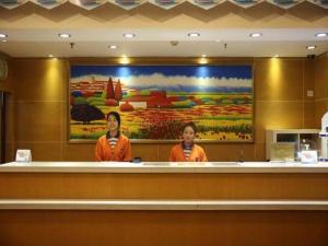 天津7 Days Inn Tianjin Anshan West Road Tianjin University的两名妇女站在餐厅柜台后面