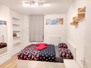 沙勒罗瓦Maison LYDIE - Meublé de vacances 3 étoiles的小卧室配有红色枕头的床