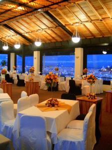 里奥班巴Hotel Zeus的宴会厅配有白色的桌椅和灯