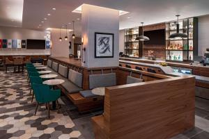 印第安纳波利斯Hyatt Place Indianapolis Downtown的餐厅设有1间带绿色椅子的酒吧