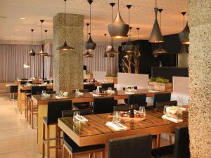 伦敦Sanderson London的餐厅设有木桌、椅子和吊灯