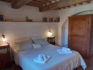 Le Piazze方泰奥拉农家乐的卧室配有白色床和毛巾