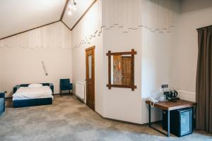 斯基希德尼萨Osonnya Karpaty RESORT MEDICAL & SPA的一间卧室配有一张床、一张桌子和一面镜子