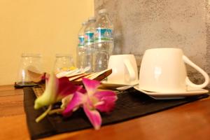 奥南海滩The Meeting House Aonang - self service的桌子上放着两杯,鲜花