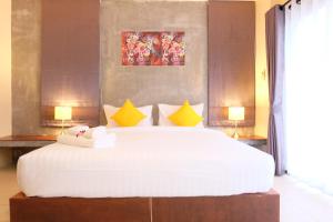 奥南海滩The Meeting House Aonang - self service的卧室配有一张带黄色枕头的大型白色床。