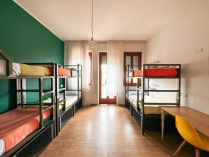 米兰Ostello Bello Milano Centrale的客房设有三张双层床和一张桌子。