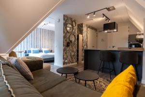 东卡佩勒Hello Zeeland - Appartement Duno Lodge M的带沙发的客厅和位于客房内的酒吧