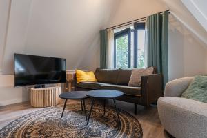 东卡佩勒Hello Zeeland - Appartement Duno Lodge M的带沙发和电视的客厅