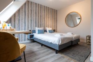 东卡佩勒Hello Zeeland - Appartement Duno Lodge M的一间卧室配有一张床、一张桌子和一面镜子