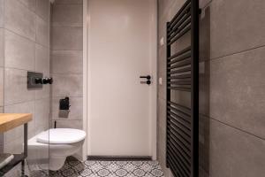 东卡佩勒Hello Zeeland - Appartement Duno Lodge M的一间带白色卫生间和门的浴室