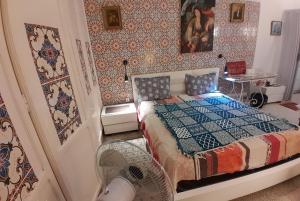 拉马萨The 18, Marsa Guest House的一间卧室配有一张床和一个风扇