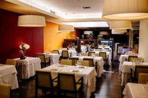 圣卡洛斯拉腊皮塔坎巴蒂斯特酒店的用餐室配有桌椅和白色桌布
