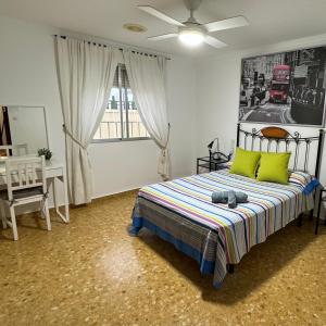甘迪亚Habitaciones en GANDIA a 5 min del centro histórico的一间卧室配有一张带两个绿色枕头的床