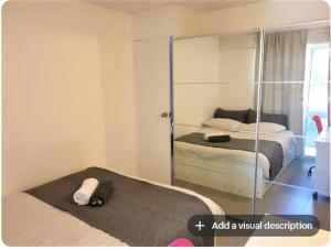 堪培拉Dana-Private Room in 3-Bedroom Apartment-1的一间卧室配有两张床和镜子