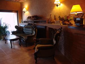 布拉索夫贝拉穆兹卡酒店的一间设有椅子、一张桌子和灯具的等候室