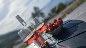 ÅfarnesHjortehytte的一辆汽车上的一碗草莓和一瓶葡萄酒