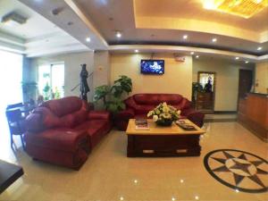 奥隆阿波彩虹园酒店的客厅配有红色皮革沙发和咖啡桌