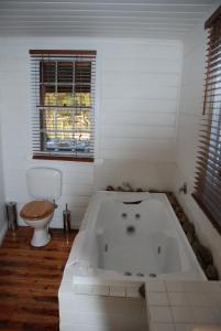 Metcalfe曼库索乡村小屋农家乐的白色的浴室设有浴缸和卫生间。