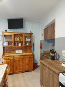 兰佐莫蒂坎塞Appartamento Novecento的一间带木制橱柜的厨房和一台墙上的电视