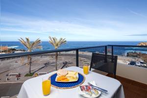 莫尼兹港Pérola Views Inn by Madeira Sun Travel的一张带食物的桌子,享有海景